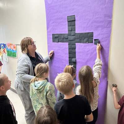 Staff and students consider their own sins, then place those sins on the cross.